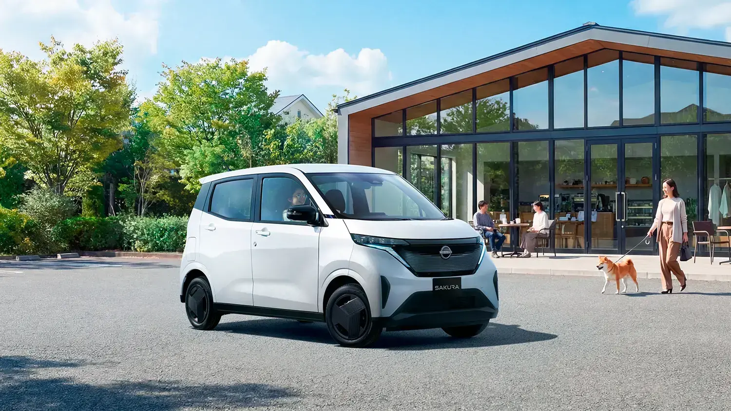 街路樹のある道を走る2026年型日産サクラ